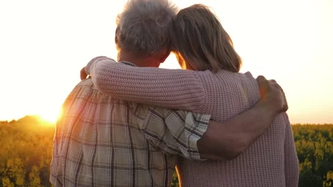 Senior couple embracing affectionately in a sunset field Vídeo Stock 330013991