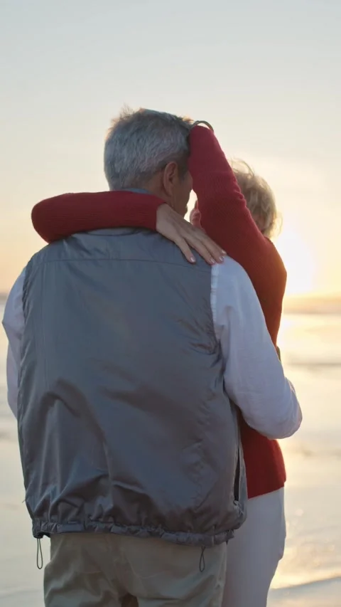 Senior couple embracing on beach at sunset Stock Footage 327715460