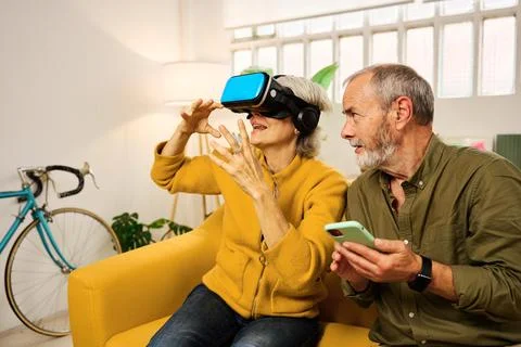 Senior couple exploring virtual reality at home Stock Photos