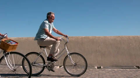 Senior couple going on a bike ride on the pier Stock Footage