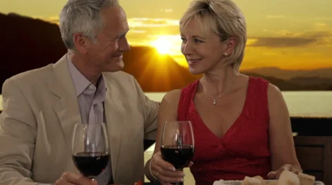 Senior couple having dinner in sunset, toasting camera Stock Footage 43678682