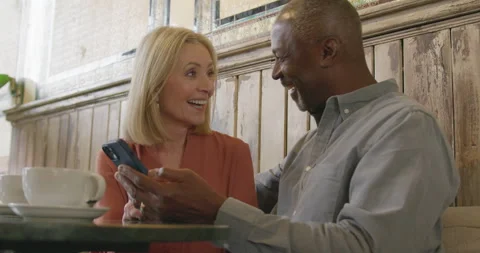 Senior Couple Having Fun in Cafe, Looking at Phone Stock Footage 247086763