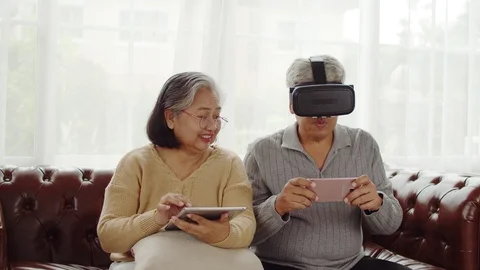 Senior couple having fun to playing game in VR glasses Stock Footage 118950285