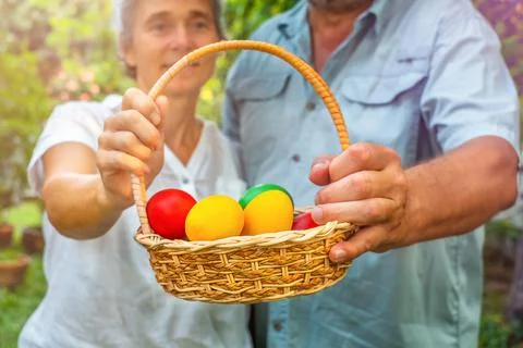 Senior couple holding basket with easter eggs Stock Photos