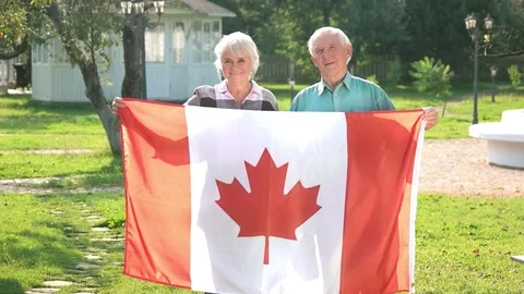 Senior couple holding Canadian flag. Stock Footage