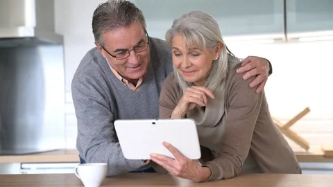  	Senior couple at home using digital tablet Stock Footage 72137816