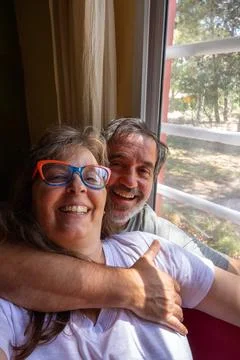 Senior couple hugging and smiling, enjoying retirement at home Stock Photos