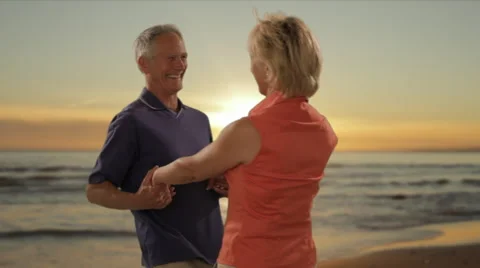 Senior couple hugging on beach with sunset and sea background Stock Footage 43678833