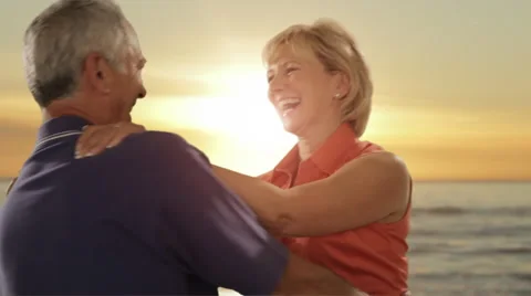 Senior couple hugging on beach with sunset and  sea background Stock Footage 43678887