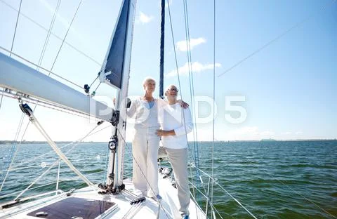 Senior couple hugging on sail boat or yacht in sea Stock Photos