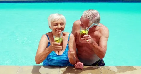Senior couple interacting with each other while having glasses of iced tea Video stock 78559404