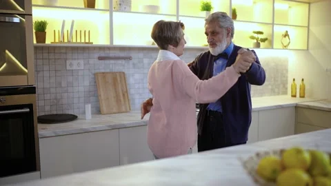 Senior couple in kitchen dancing the waltz, twirling in dance, smiling, happy Stock Footage 236167765