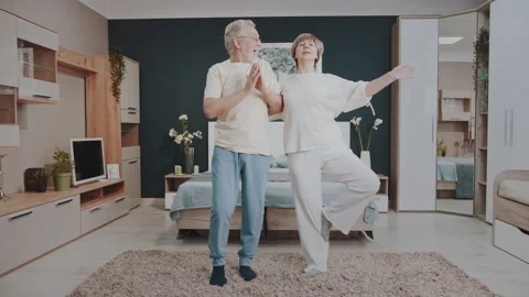 Senior couple laughing and practicing yoga poses at home Vídeos de archivo 327452821
