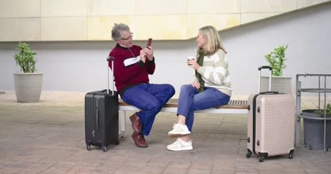 Senior couple leaning in to view smartphone after recording gesture next to Stock Footage 337704823
