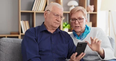 Senior couple learning smartphone for online banking and communication at home Stock Footage 333285068
