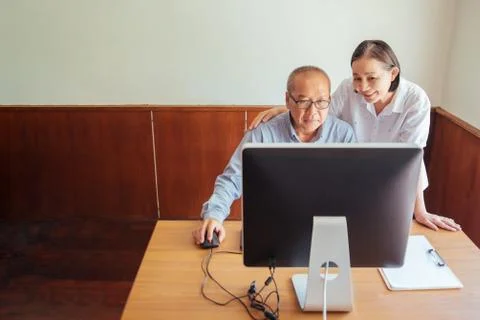 Senior Couple Looking At Desktop Computer At Desk Stock Photos