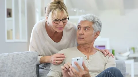 Senior couple looking at message on smartphone Stock Footage 55171362