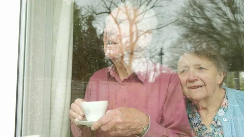 Senior couple looking out of a window Video stock 88446003