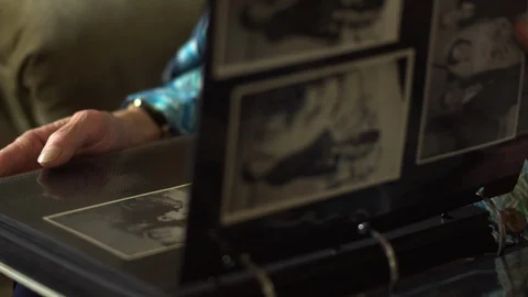 A senior couple looking over an old family photograph album. Vidéo 88367566
