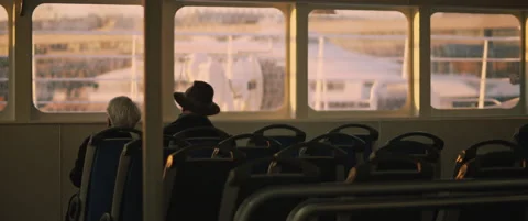 Senior couple looking at sunset from the inside of a ship cabin. Slow motion. Stock Footage 147567096