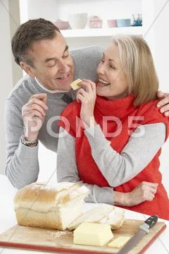 Senior Couple Making Sandwich In Kitchen Stock-Fotos