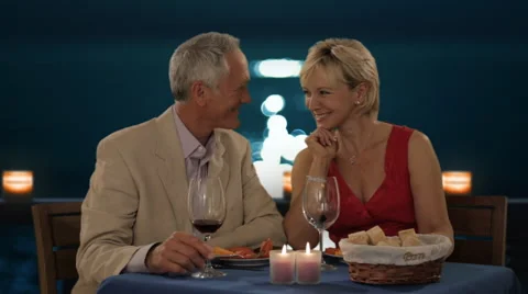 Senior couple in moonlight having dinner waiter pouring wine Stock Footage 43678309