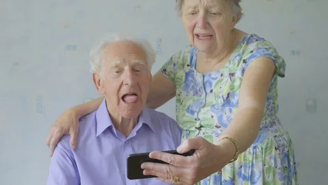 Senior couple pulling funny faces at a smartphone Video stock 89921584