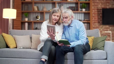 Senior couple reading e-book on digital tablet. Happy modern gray mature family  Stock Footage 172498323