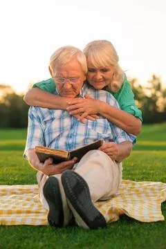 Senior couple reads book. Senior couple reads book. Two people sitting on ... Stock Photos