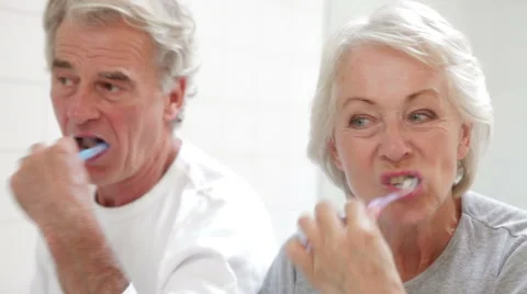 Senior Couple Reflected In Bathroom Mirror Brushing Teeth Stock Footage 51299469
