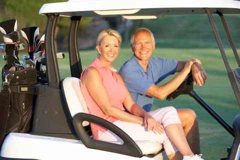 Senior Couple Riding In Golf Buggy On Golf Course Stock Photos