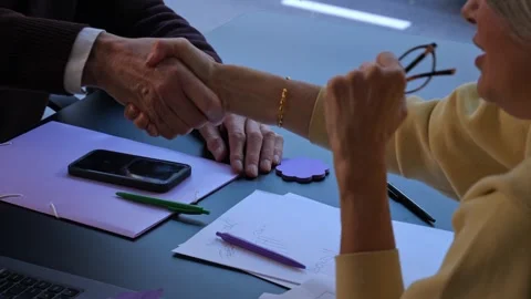Senior couple shaking hands over desk with documents and smartphone Vídeo Stock 341677707