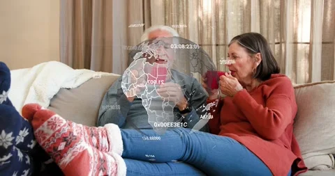 Senior couple sharing holiday chat, sipping mugs, globe appearing over couple Stock Footage 321734532