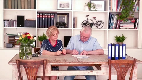 Senior couple signing documents by table at home Stock-Footage 97480403