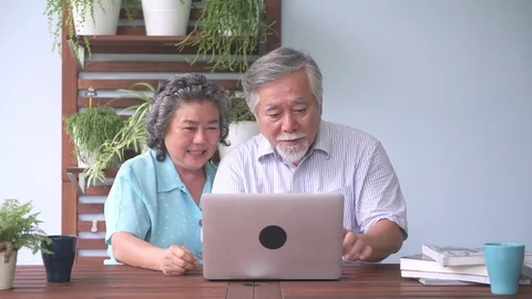 Senior couple sitting and using laptop in balcony. Stock Footage 98387998