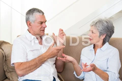 Senior couple sitting on couch having an argument Stock Photos