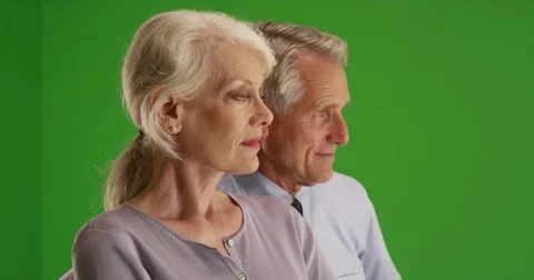 Senior couple sitting at home looking out the window on green screen Stock Footage