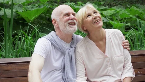 Senior couple sitting in park. Active modern life after retirement. Happy family Stock Footage 103864796