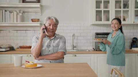 Senior couple smiling at dining table in home kitchen with breakfast coffee.. Stock Footage 332748728