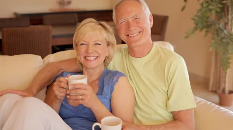 Senior couple on sofa drinking tea or coffee Stock Footage 43622487