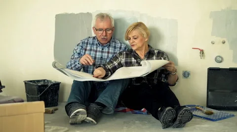 Senior couple talking and checking blueprints at their new home Stock Footage 65442849