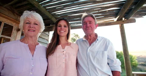 Senior couple with their adult daughter smiling for a portrait Stock Footage