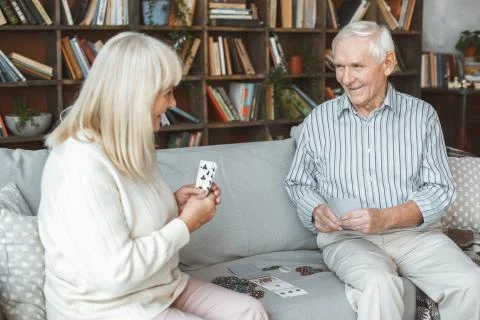 Senior couple together at home retirement concept playing cards gambling Stock Photos