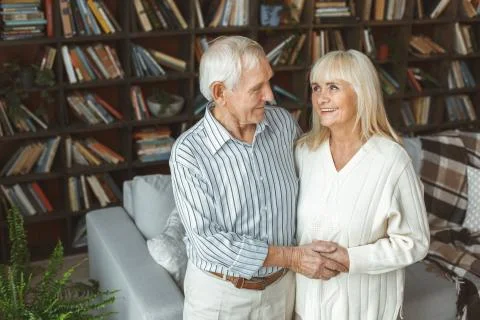 Senior couple together at home retirement concept standing holding hands Stock Photos