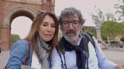 Senior couple of tourist looking at map at city street. Stock Footage 243674574