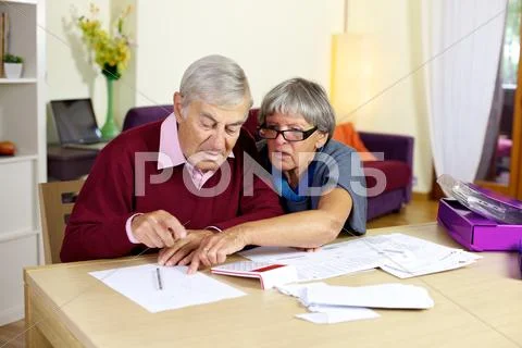 Senior couple in trouble calculating bills and taxes Stock Photos