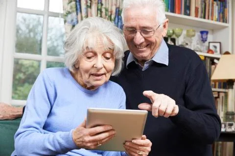 Senior Couple Using Digital Tablet At Home Stock Photos