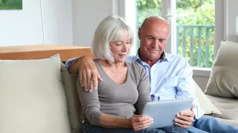 Senior couple using electronic tablet at home Stock Footage 14829285