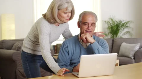 Senior couple using laptop computer together Stock Footage