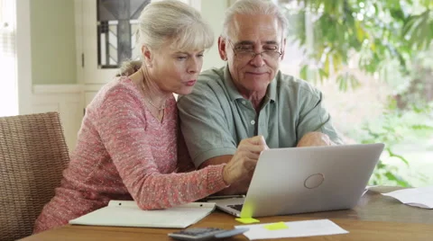 Senior couple using laptop computer to pay bills Stock Footage